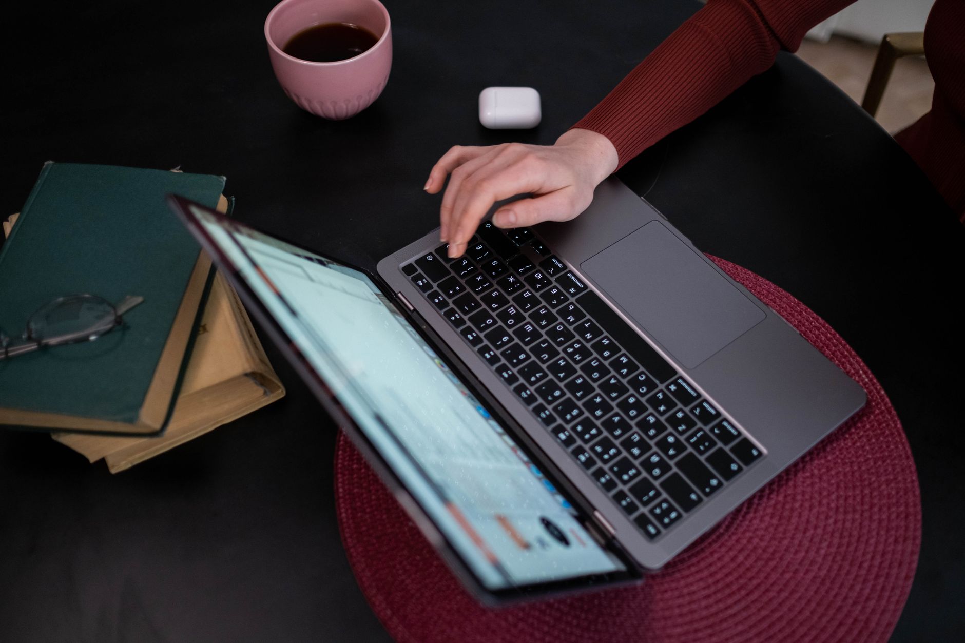 A person types on a laptop at a desk